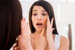 worried-about-acne-frustrated-young-woman-examini-2022-02-06-07-49-14-utc