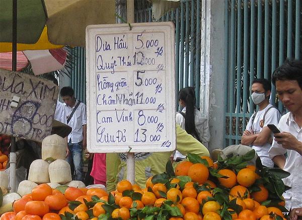 Các xe đẩy bán trái cây gần chợ Gò Vấp với cách ghi giá “1/2 kg”.